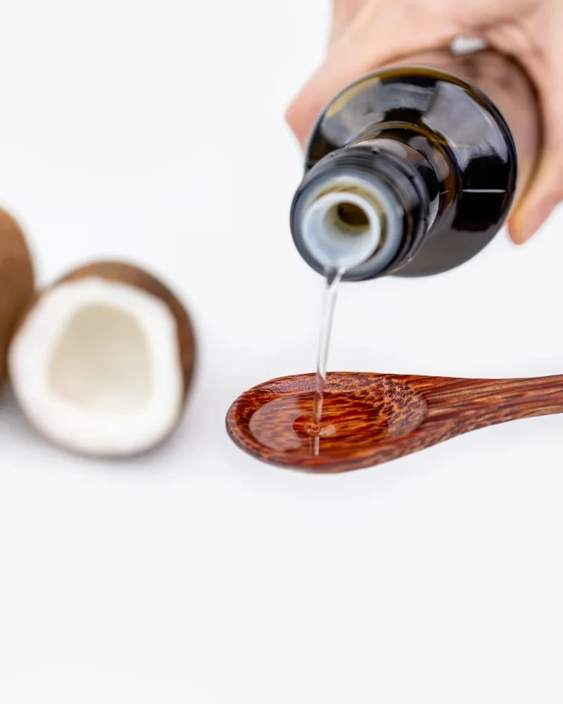 Reines Vilgain MCT Öl C8 aus 100% Kokosnuss wird auf einen Holzlöffel gegossen – ideal für Ketose.